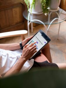 Adult man browsing on a tablet while relaxing indoors, technology focus.